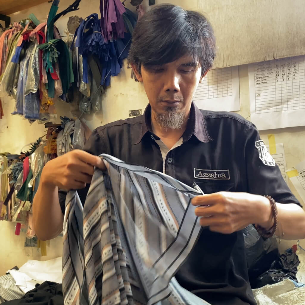 seseorang sedang melakukan quality control, untuk produk hijab yang berkualitas