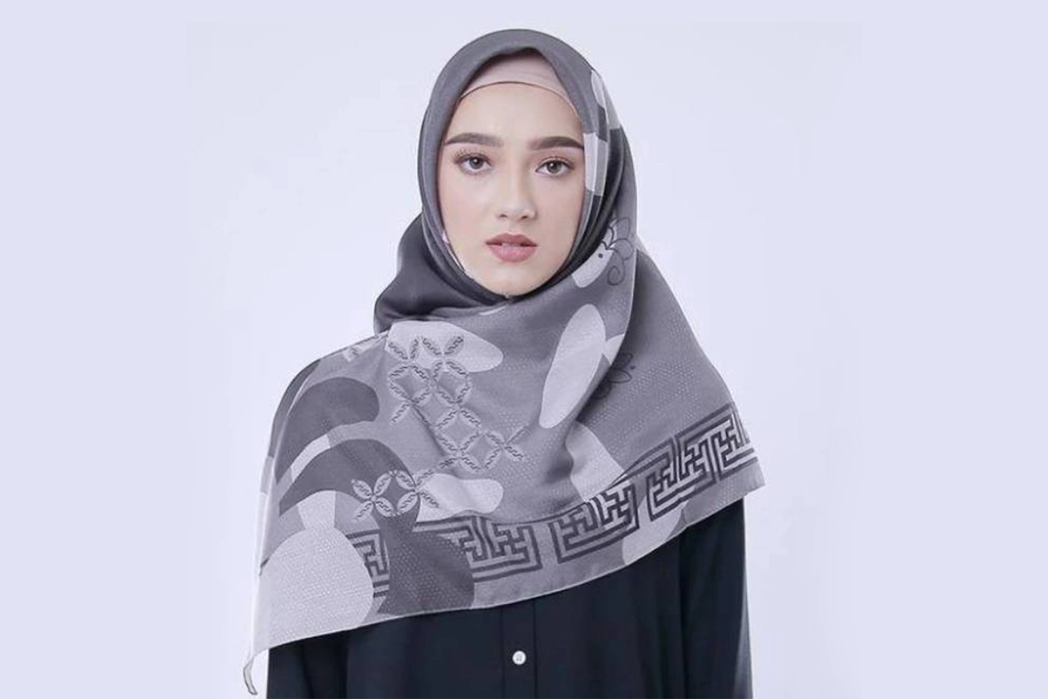 Seorang wanita menggunakan hijab dengan motif abstrak.