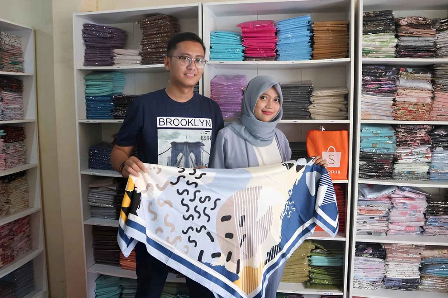 Business owner reviewing hijab sales target examples.