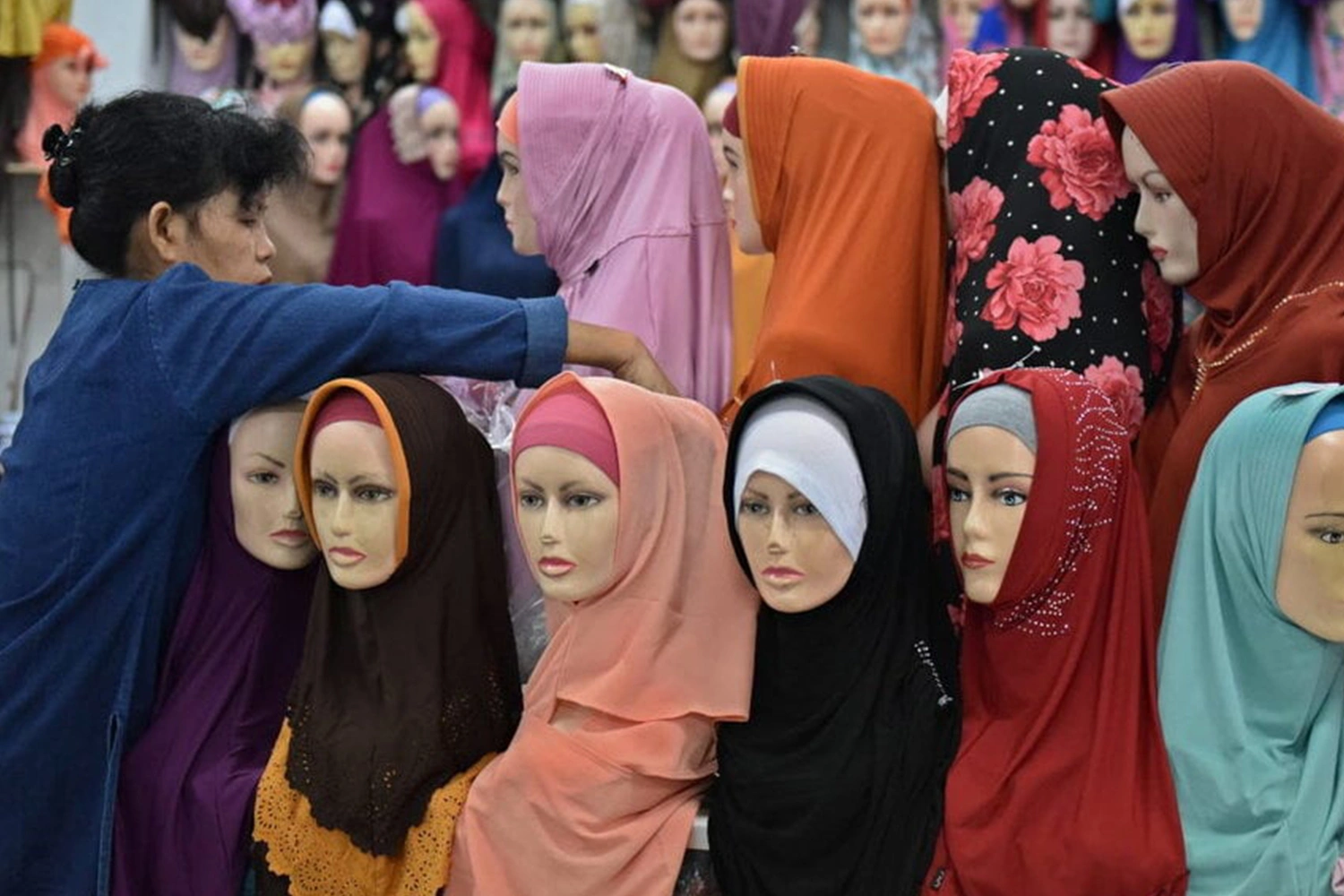 Entrepreneur conducting market research for hijab business with charts, surveys, and fashion trend analysis.