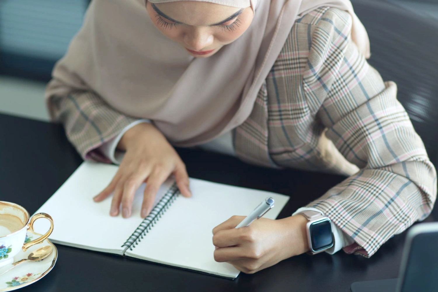 Pebinsis sedang menghitung margin keuntungan ketika berbisnis hijab.