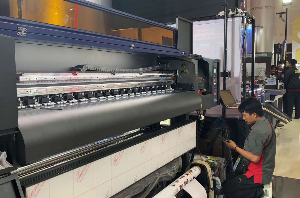 Demo mesin printing Laysander di Surabaya Printing Expo 2025 menunjukkan proses cetak langsung di booth.