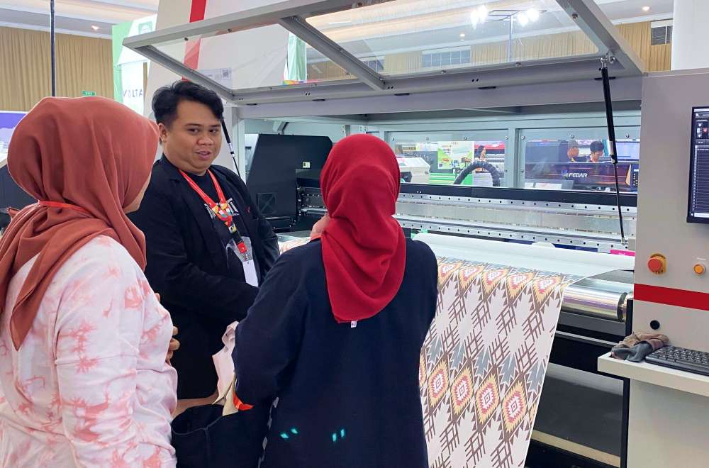 Pengunjung melihat demo mesin printing modern dari Laysander pada pameran IAPE Bandung 2025.