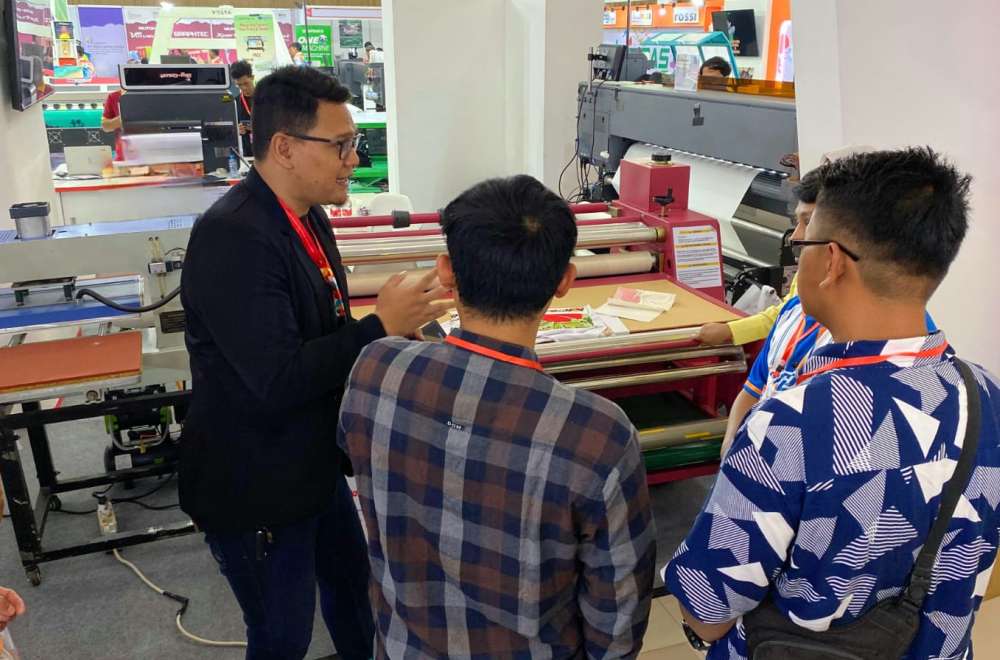 Peserta pameran melihat demo mesin digital printing pada IAPE Bandung 2025 di Bandung Convention Center.