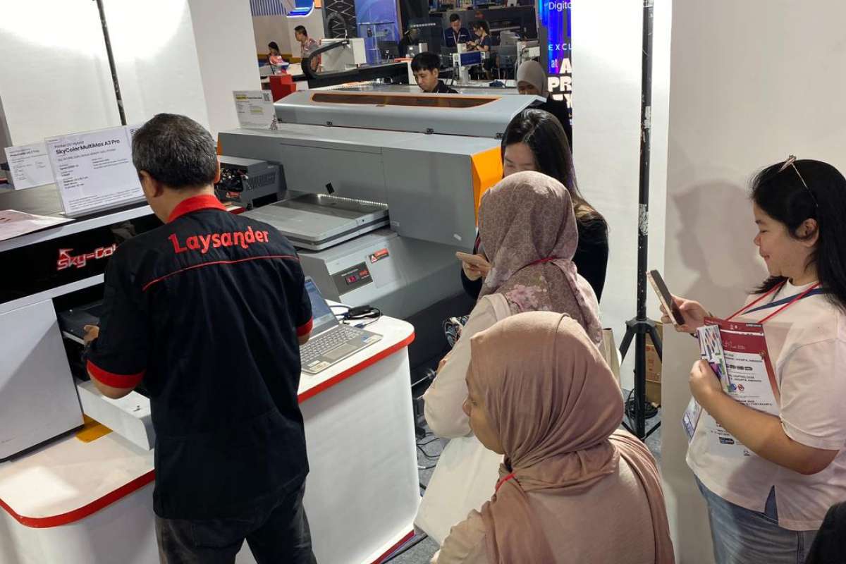 Visitors observing a live demo of advanced printing machines at the Laysander booth during the All Print 2025 Exhibition.