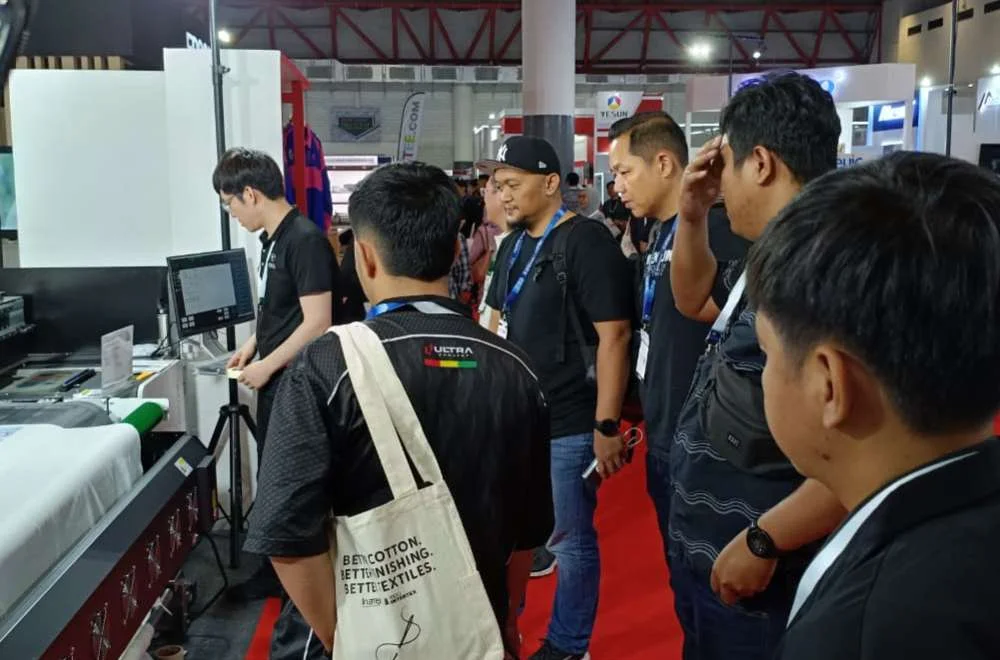 Pengunjung melihat demo mesin tekstil di pameran Indo Intertex 2026 dengan penawaran promo menarik untuk investasi bisnis.