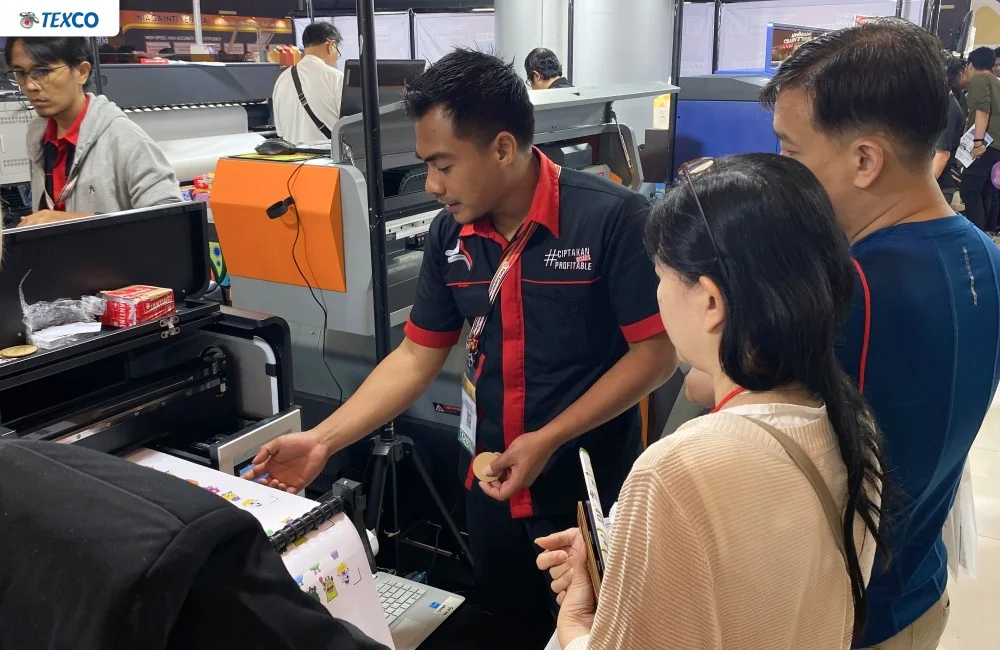 Pengunjung menyaksikan demonstrasi langsung mesin printing di booth pameran surabaya printing expo 2026 untuk melihat kualitas dan performa cetak.
