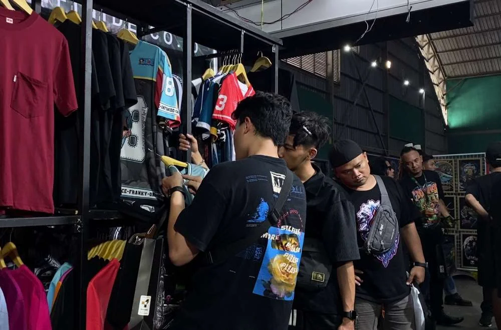 Pengunjung melihat produk apparel dan hasil sablon di area pameran event Kenduri Sablon Jogja #3 bersama komunitas pelaku usaha kreatif.