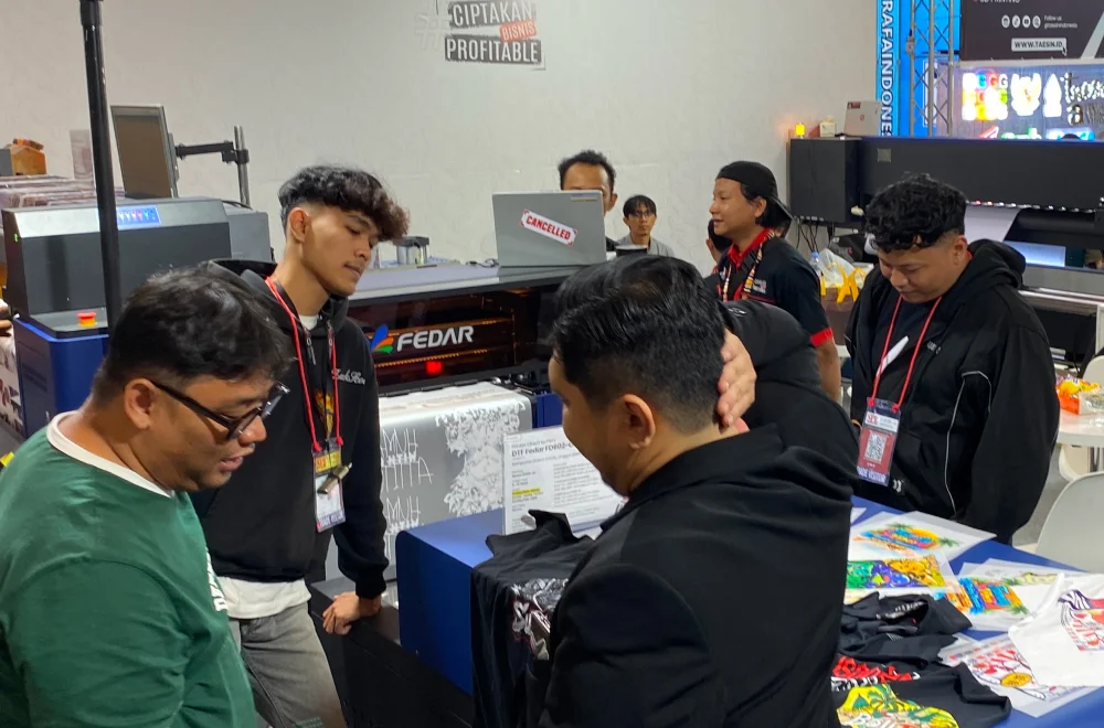 Pengunjung menyaksikan demonstrasi mesin cetak digital dan berdiskusi dengan tim di booth Surabaya Printing Expo 2026 untuk menemukan solusi produksi yang sesuai.